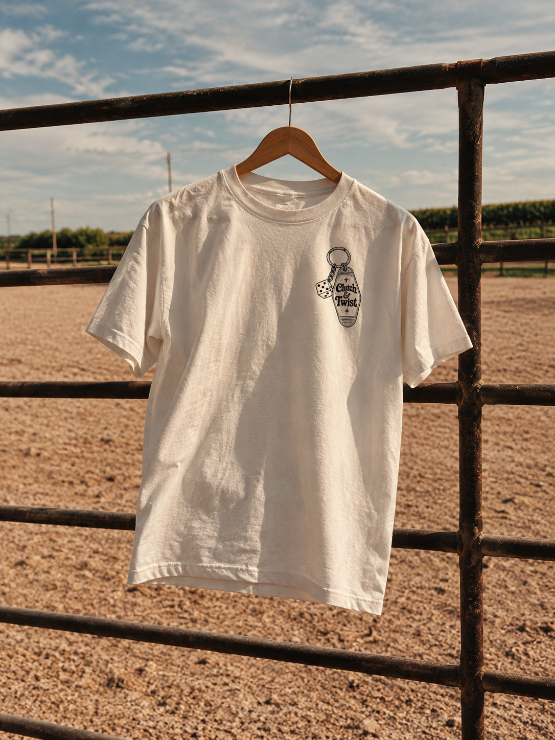 Clutch & Twist motel t-shirt hanging on a ranch gate